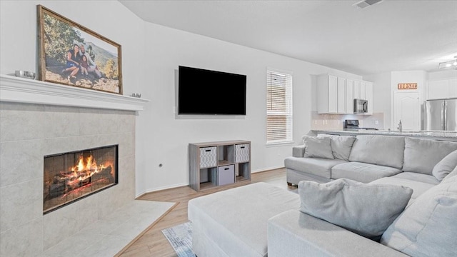 17734 Pensford Way, Tomball, TX 77377 - living area featuring light wood-style floors and a fireplace
