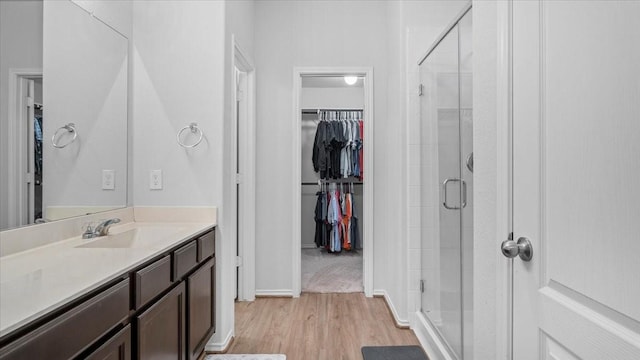 17734 Pensford Way, Tomball, TX 77377 - bathroom with a walk in closet, a stall shower, wood finished floors, and vanity