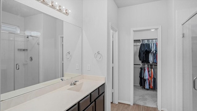 17734 Pensford Way, Tomball, TX 77377 - full bathroom featuring wood finished floors, a shower stall, a walk in closet, and vanity