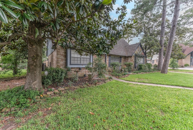 410 Shadywood Cir, Conroe, TX 77304 - view of front of home with brick siding, a front yard, and a shingled roof