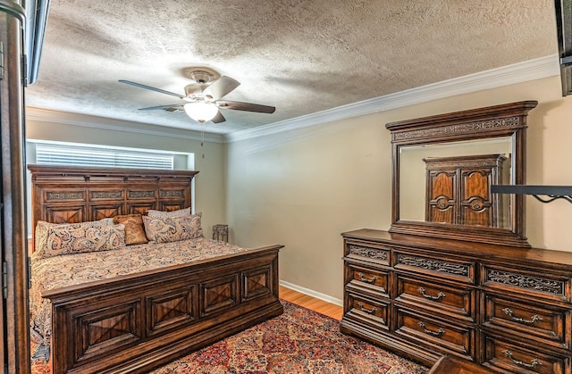 410 Shadywood Cir, Conroe, TX 77304 - bedroom featuring wood finished floors, a textured ceiling, crown molding, and ceiling fan