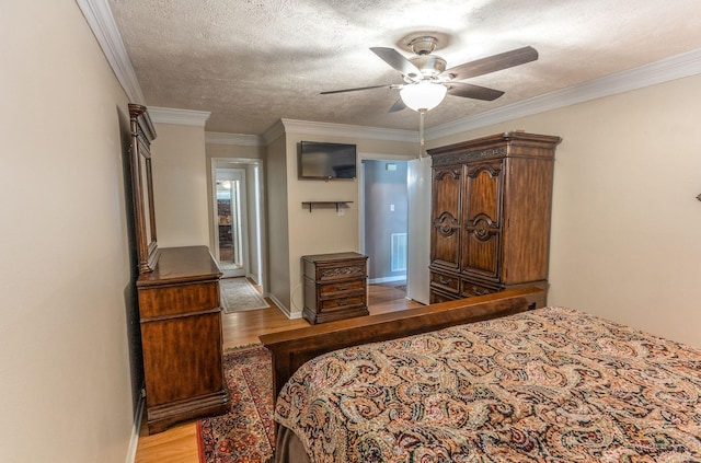 410 Shadywood Cir, Conroe, TX 77304 - bedroom featuring light wood-style floors, ornamental molding, ceiling fan, and a textured ceiling