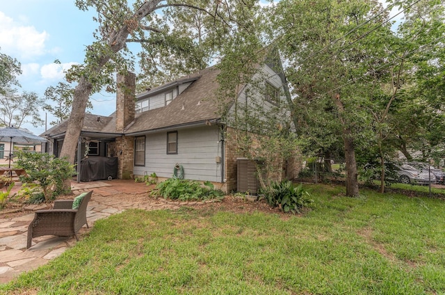 410 Shadywood Cir, Conroe, TX 77304 - back of house featuring a patio, a chimney, a lawn, and a shingled roof
