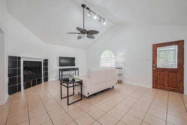 511 Walston Ln, Houston, TX 77060 - living area featuring track lighting, lofted ceiling, ceiling fan, light tile patterned floors, and a fireplace