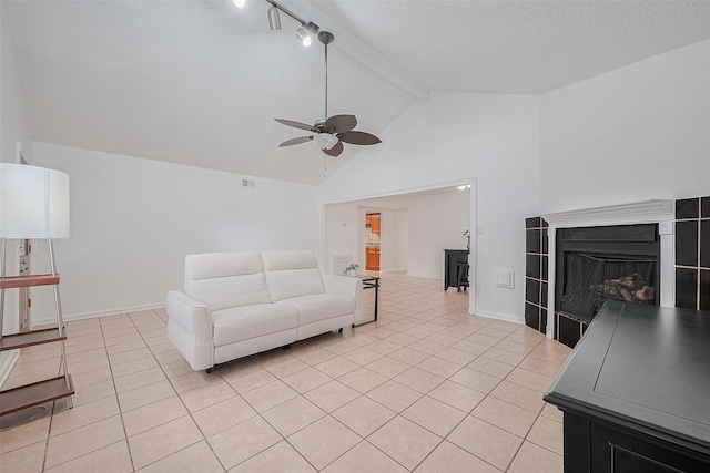 511 Walston Ln, Houston, TX 77060 - living area with a ceiling fan, light tile patterned floors, beam ceiling, a fireplace, and a textured ceiling