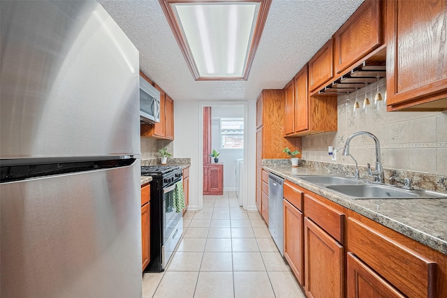 511 Walston Ln, Houston, TX 77060 - kitchen with appliances with stainless steel finishes, brown cabinetry, light tile patterned floors, a textured ceiling, and decorative backsplash