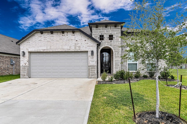 14715 Poplar Lake Trl, Cypress, TX 77429 - french country home featuring stone siding, a front yard, an attached garage, and driveway