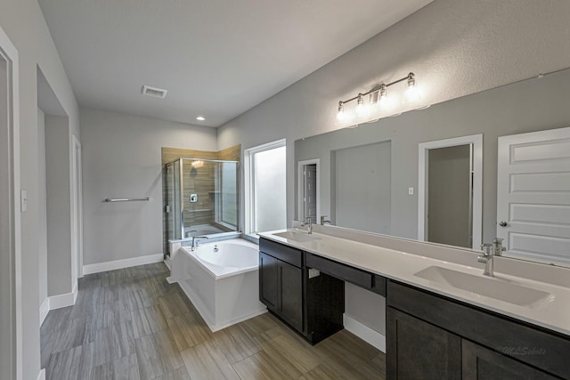 14715 Poplar Lake Trl, Cypress, TX 77429 - bathroom featuring a shower stall, a garden tub, double vanity, recessed lighting, and wood finished floors