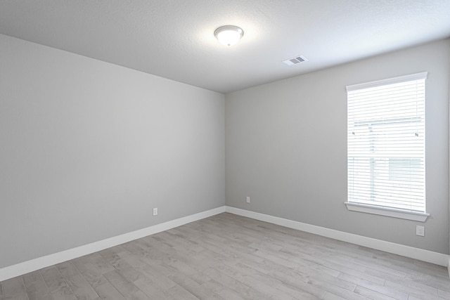 14715 Poplar Lake Trl, Cypress, TX 77429 - empty room with light wood-type flooring, healthy amount of natural light, and a textured ceiling