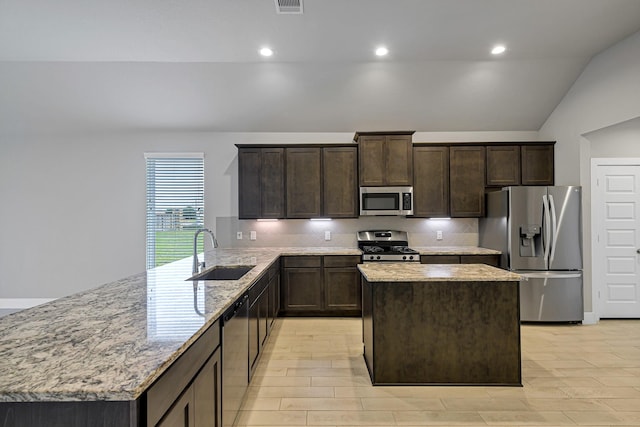 14715 Poplar Lake Trl, Cypress, TX 77429 - kitchen with stainless steel appliances, dark brown cabinets, backsplash, a center island, and vaulted ceiling