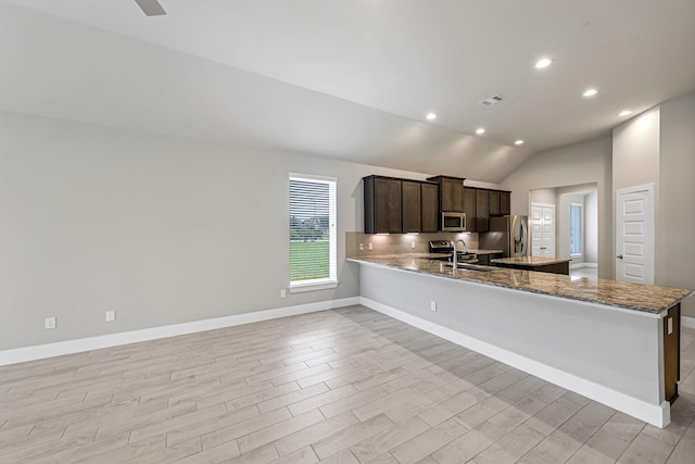 14715 Poplar Lake Trl, Cypress, TX 77429 - kitchen featuring stainless steel appliances, light wood-type flooring, lofted ceiling, a peninsula, and dark brown cabinets