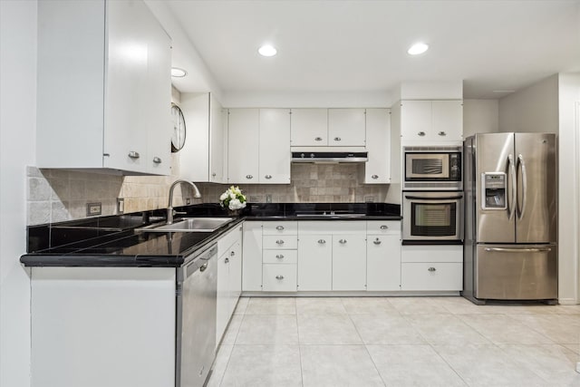 9333 Memorial Dr Unit 301, Houston, TX 77024 - kitchen featuring appliances with stainless steel finishes, under cabinet range hood, white cabinets, dark countertops, and tasteful backsplash
