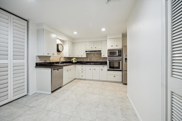 9333 Memorial Dr Unit 301, Houston, TX 77024 - kitchen featuring appliances with stainless steel finishes, dark countertops, backsplash, light tile patterned floors, and recessed lighting