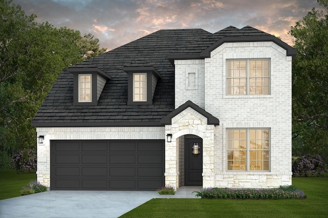 16019 Tangled Vine Ln, Conroe, TX 77378 - french country inspired facade featuring driveway, a garage, stone siding, brick siding, and a front lawn