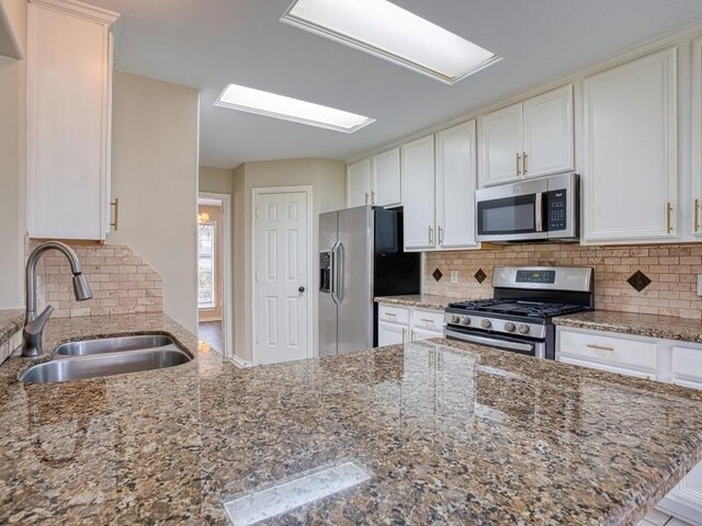26610 W Surrey Park Ln W, Katy, TX 77494 - kitchen featuring stainless steel appliances, decorative backsplash, stone counters, and white cabinetry