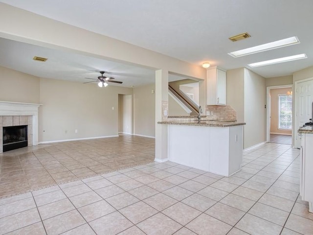 26610 W Surrey Park Ln W, Katy, TX 77494 - kitchen with light tile patterned floors, white cabinetry, light stone countertops, decorative backsplash, and ceiling fan