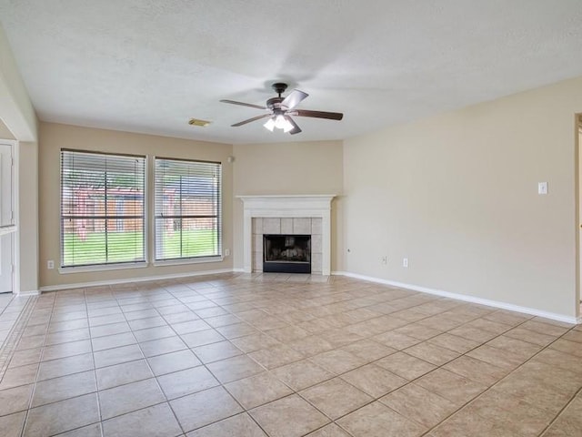 26610 W Surrey Park Ln W, Katy, TX 77494 - unfurnished living room featuring ceiling fan, light tile patterned flooring, a fireplace, and a textured ceiling