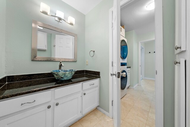 8416 Seawall Blvd Unit 5, Galveston, TX 77554 - bathroom featuring stacked washing machine and dryer, vanity, and marble look tiles