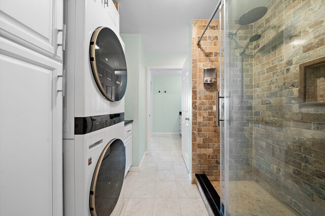 8416 Seawall Blvd Unit 5, Galveston, TX 77554 - washroom with stacked washer / drying machine and light marble finish flooring