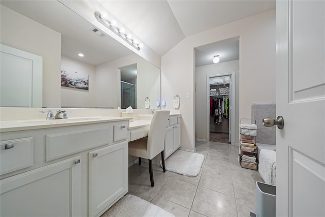 16330 Hillside Garden Ln, Houston, TX 77084 - bathroom featuring double vanity, a shower stall, a walk in closet, tile patterned flooring, and lofted ceiling