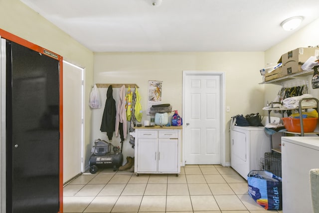 1732 Lynn Ln, Freeport, TX 77541 - laundry area featuring washer and clothes dryer, light tile patterned floors, and cabinet space