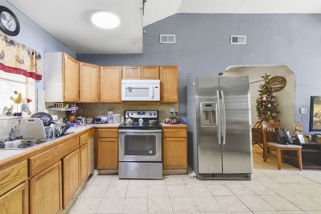 1732 Lynn Ln, Freeport, TX 77541 - kitchen featuring appliances with stainless steel finishes, light countertops, light tile patterned flooring, and high vaulted ceiling