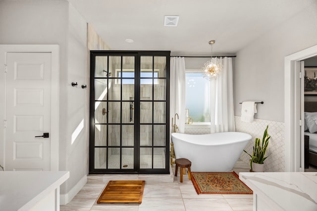 915 Bernard Meadows Dr, East Bernard, TX 77435 - full bath featuring a soaking tub, tile walls, and a chandelier