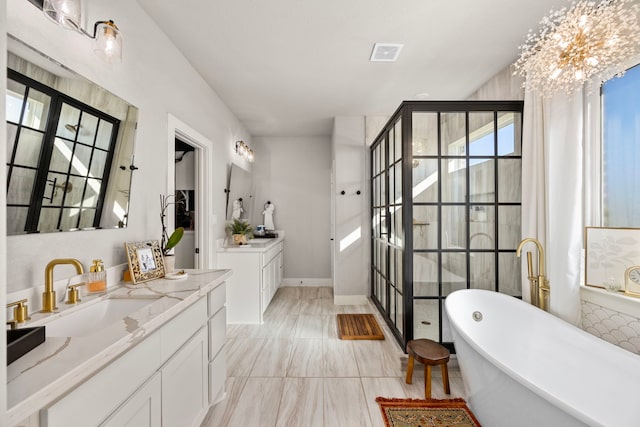915 Bernard Meadows Dr, East Bernard, TX 77435 - bathroom featuring two vanities, a freestanding bath, a stall shower, and a chandelier