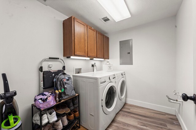 111 Mesa Ct, Conroe, TX 77304 - laundry room with electric panel, separate washer and dryer, light wood finished floors, and cabinet space