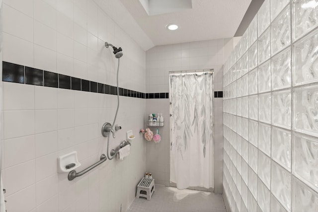 111 Mesa Ct, Conroe, TX 77304 - full bath featuring a tile shower, tile walls, tile patterned flooring, recessed lighting, and a textured ceiling