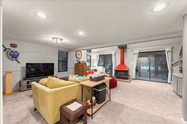 111 Mesa Ct, Conroe, TX 77304 - living room featuring light carpet, a textured ceiling, a wood stove, recessed lighting, and ornamental molding