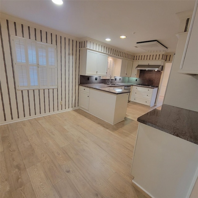 5227 Imogene St, Houston, TX 77096 - kitchen featuring light wood-style flooring, a peninsula, ventilation hood, white cabinets, and gas cooktop
