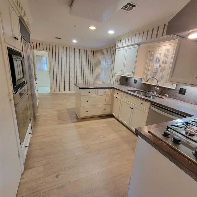 5227 Imogene St, Houston, TX 77096 - kitchen with extractor fan, a peninsula, light wood finished floors, wall oven, and recessed lighting