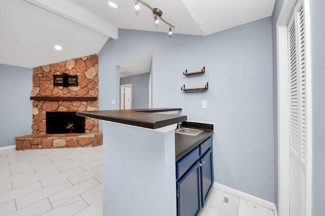 10731 Forest Leaf Dr, Sugar Land, TX 77498 - kitchen featuring blue cabinets, dark countertops, a fireplace, open floor plan, and a peninsula