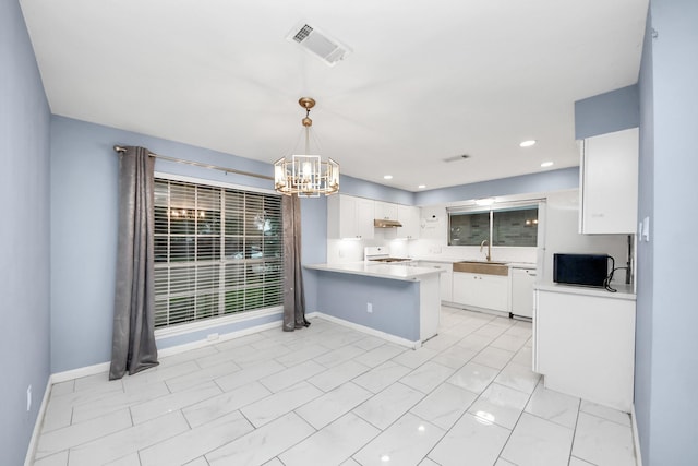 10731 Forest Leaf Dr, Sugar Land, TX 77498 - kitchen featuring stove, a chandelier, a peninsula, light countertops, and white cabinetry