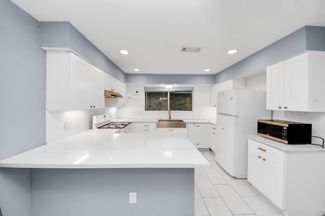 10731 Forest Leaf Dr, Sugar Land, TX 77498 - kitchen with white appliances, under cabinet range hood, a peninsula, light countertops, and decorative backsplash