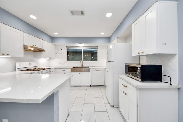 10731 Forest Leaf Dr, Sugar Land, TX 77498 - kitchen featuring white appliances, under cabinet range hood, light marble finish floors, a peninsula, and white cabinetry