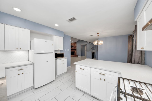 10731 Forest Leaf Dr, Sugar Land, TX 77498 - kitchen with freestanding refrigerator, stainless steel microwave, white cabinetry, a peninsula, and tasteful backsplash