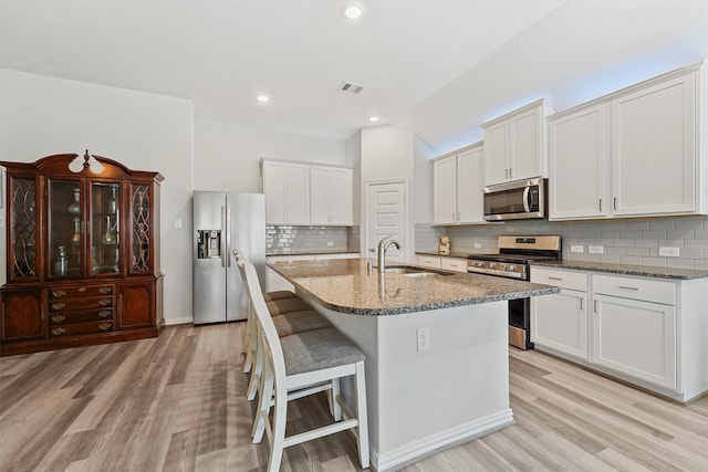 1203 Casal Springs Ct, Crosby, TX 77532 - kitchen with appliances with stainless steel finishes, stone countertops, a kitchen breakfast bar, tasteful backsplash, and recessed lighting
