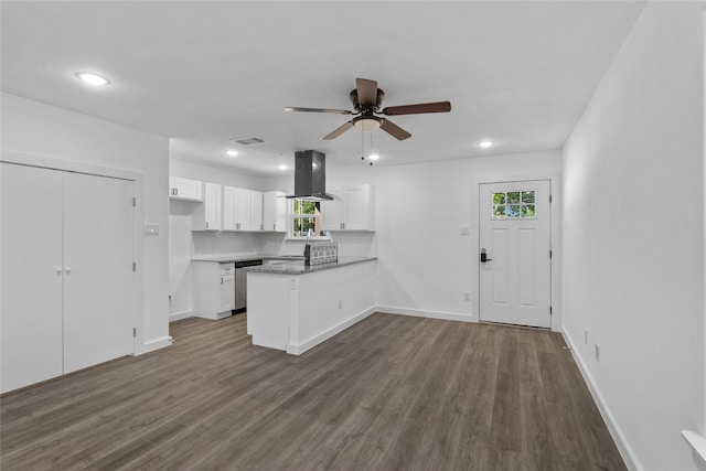 7613 Shotwell St, Houston, TX 77016 - kitchen featuring island exhaust hood, a peninsula, white cabinets, plenty of natural light, and recessed lighting