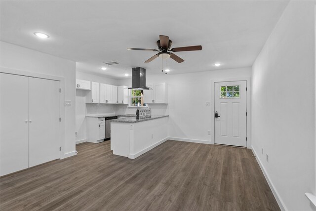 7613 Shotwell St, Houston, TX 77016 - kitchen with island exhaust hood, a peninsula, white cabinets, plenty of natural light, and recessed lighting