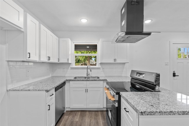 7613 Shotwell St, Houston, TX 77016 - kitchen featuring stainless steel appliances, range hood, a peninsula, healthy amount of natural light, and recessed lighting