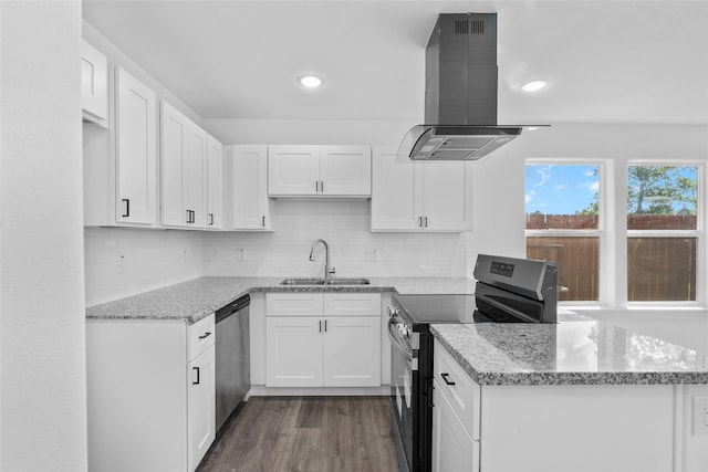 7613 Shotwell St, Houston, TX 77016 - kitchen with stainless steel appliances, island exhaust hood, white cabinetry, a peninsula, and tasteful backsplash