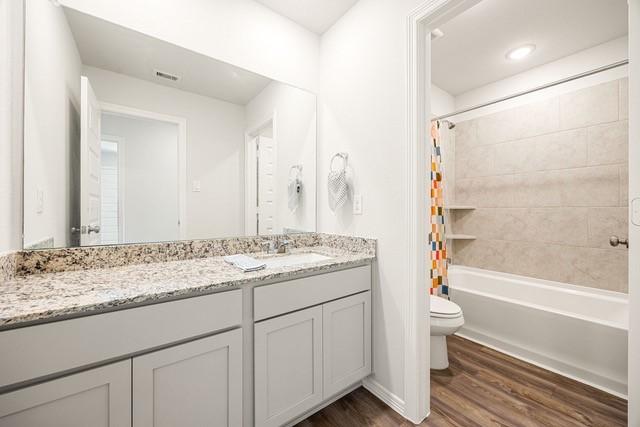 23242 Spring Genesis Ln, Katy, TX 77493 - bathroom with wood finished floors, vanity, and shower / bathtub combination with curtain