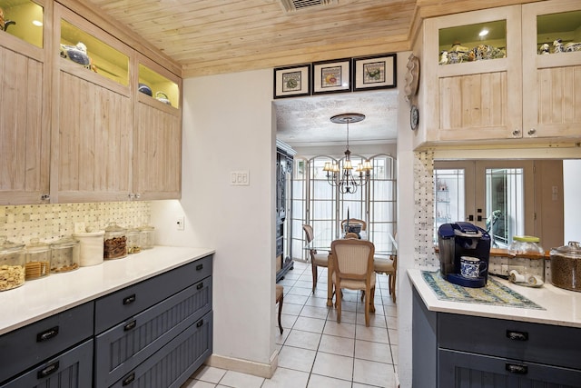 12148 Stone W Dr, Houston, TX 77035 - kitchen featuring light tile patterned floors, a chandelier, light countertops, glass insert cabinets, and light brown cabinetry