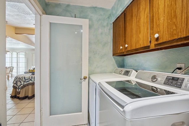 12148 Stone W Dr, Houston, TX 77035 - laundry area with cabinet space, independent washer and dryer, and light tile patterned flooring