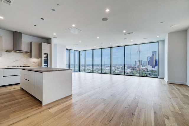 1711 Allen Pkwy Unit 2106, Houston, TX 77019 - kitchen with wall chimney exhaust hood, modern cabinets, open floor plan, a wall of windows, and recessed lighting