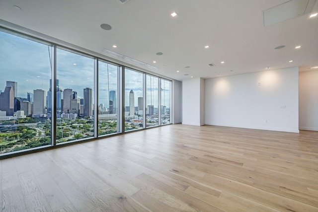 1711 Allen Pkwy Unit 2106, Houston, TX 77019 - spare room with light wood-style floors, a skyline view, expansive windows, and recessed lighting