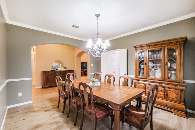 13330 Via Torre De Pisa Ln, Cypress, TX 77429 - dining room featuring arched walkways, a chandelier, light wood finished floors, and ornamental molding