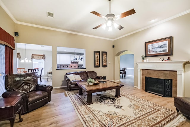 13330 Via Torre De Pisa Ln, Cypress, TX 77429 - living room featuring arched walkways, light wood-style floors, crown molding, a ceiling fan, and a chandelier